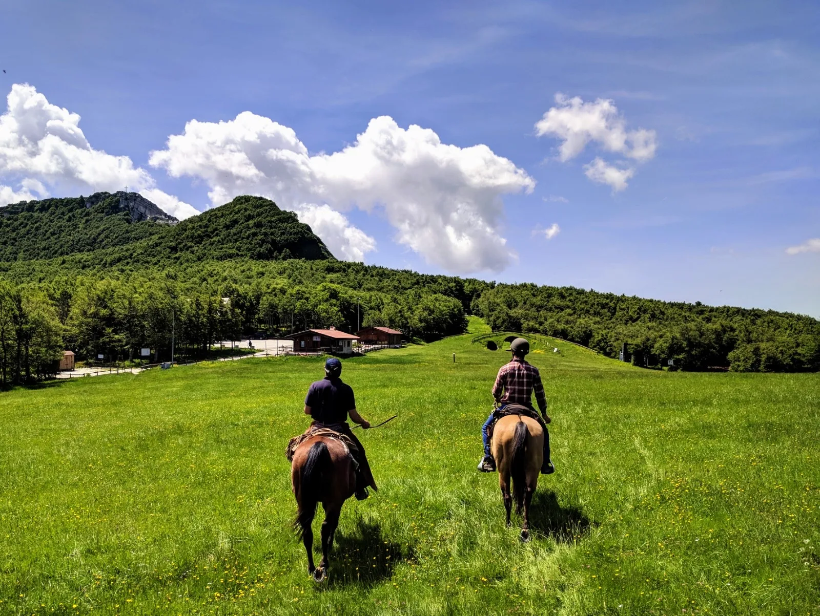 Due cavalieri attraversano un prato di montagna nell'Alto Molise
